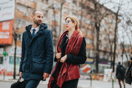 Business professionals walking outdoors discussing work on a casual city day