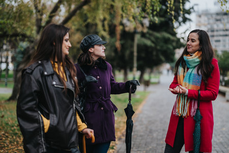 Group of Women Conversing Together Outdoors on a Rainy Day in the Cityの写真素材