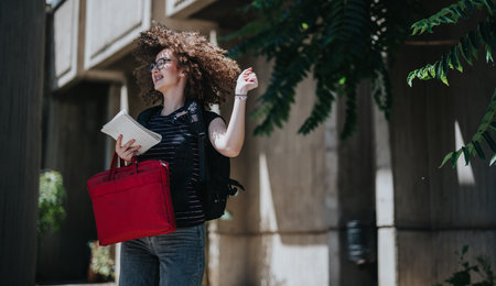 Student enjoying outdoors with school supplies in a school courtyard settingの写真素材