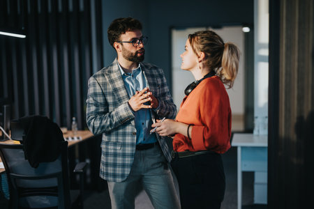 Colleagues discussing work in modern office settingの写真素材