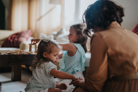 Mother spending quality time with her young daughters at homeの写真素材