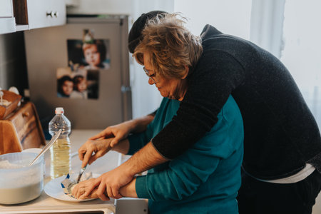Elderly woman and man cooking together in a cozy kitchen settingの写真素材
