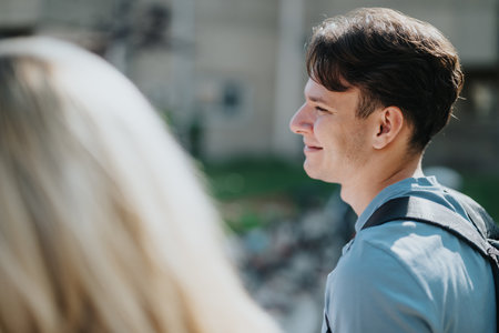 Friendly student outdoors with backpack and bright campus backgroundの写真素材