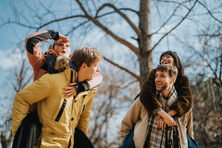 Friends enjoying a joyful moment outdoors in a bright autumn dayの写真素材