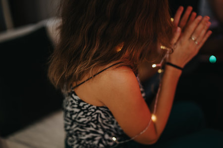 Woman enjoying a cozy indoor moment surrounded by warm lighting