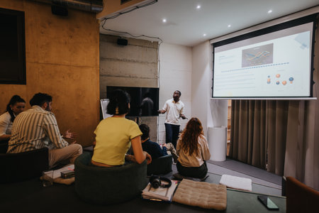 Group of people attending a presentation in a modern office setting with a projector display.