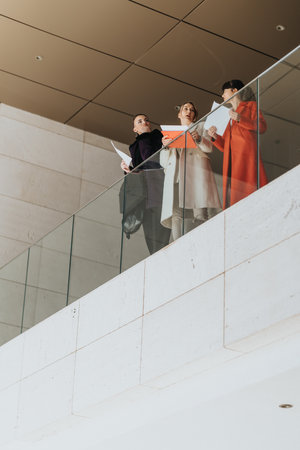 Three confident businesswomen brainstorming together in a modern office building