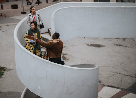 Group of diverse people conversing outdoors on a spiral staircaseの写真素材