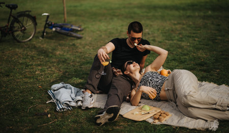 Couple Relaxing With Snacks and Drinks During a Picnic on a Sunny Dayの写真素材