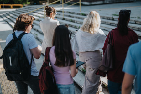 Group of students walking outside with their professor on sunny dayの写真素材