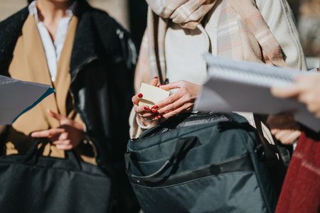 Group of business professionals discussing documents during an outdoor meetingの写真素材
