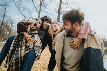Group of friends laughing and having fun outdoors in autumnの写真素材