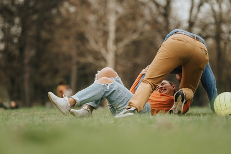 Group of friends playing in a park having fun with a soccer ballの写真素材