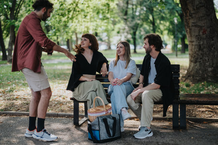 Group of adults enjoying a picnic gathering in a park outdoorsの写真素材