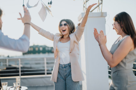 Business colleagues celebrating together on a rooftop during a bright sunny dayの写真素材