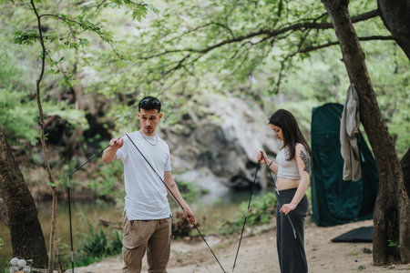 Friends assembling a tent in a forest during a camping tripの写真素材