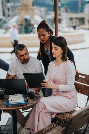 Group discussing business at outdoor casual meet up with laptop and notebooks