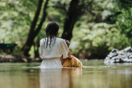 Person performing a ritual in a tranquil outdoor water settingの写真素材