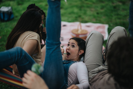 Friends enjoying a lively hammock moment in a park setting