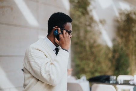 Man in white sweater talking on smart phone in an urban outdoor setting