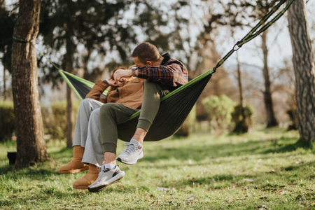 Young couple relaxing together on a hammock in a peaceful outdoor setting