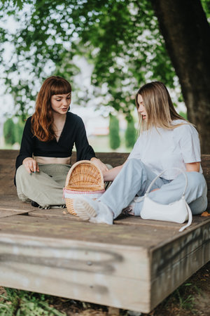 Two friends enjoying a picnic together outdoors in a park settingの写真素材