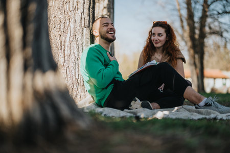 Young couple enjoying a sunny day outdoors under treesの写真素材
