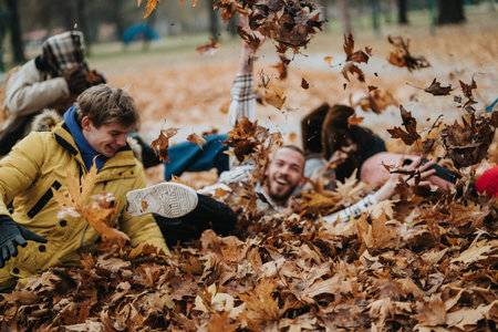 Group of Friends Playfully Enjoying a Fun Autumn Day Among Fallen Leaves Outdoors