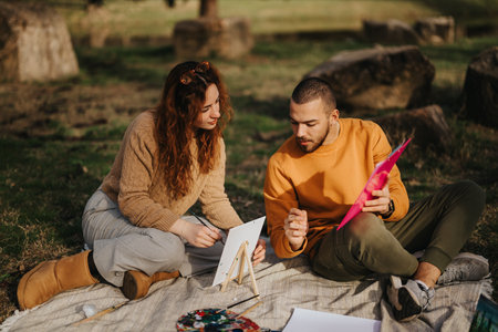 Couple painting together outdoors in a serene and natural setting
