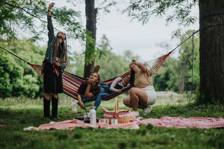 Friends enjoying a peaceful picnic in a green outdoor hammock setting