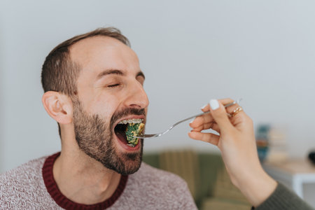 Man enjoying a meal at home while being served food