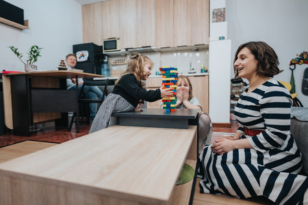 Family enjoying a playful evening at home with stackable blocksの写真素材