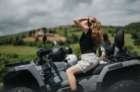 Friends enjoying an afternoon on quad bikes in the scenic countrysideの写真素材