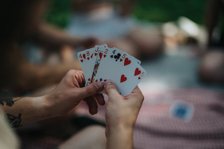 Group playing a card game on a sunny day in the parkの写真素材
