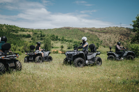 Friends riding quad bikes through scenic countryside during a sunny outdoor adventure