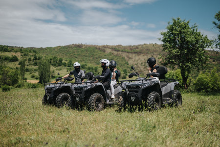 Group of friends riding quad bikes through scenic mountain trails outdoors