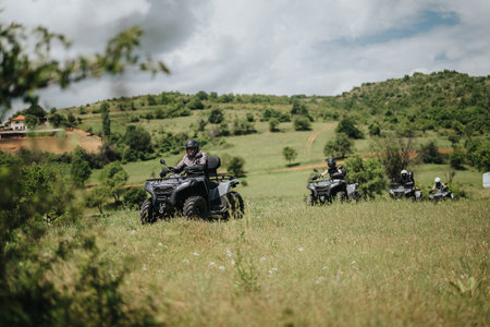 Group of friends riding quad bikes on a picturesque green landscape