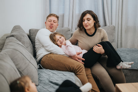 Happy family spending quality time together on a cozy living room couchの写真素材