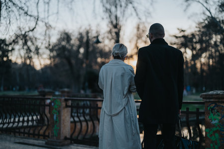 Couple enjoying a serene park view during sunset in early springの写真素材
