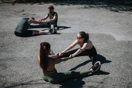 Group stretching exercises outdoors on a sunny day with diverse participantsの写真素材