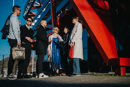 Group of professionals networking outdoors near a modern architectural structureの写真素材