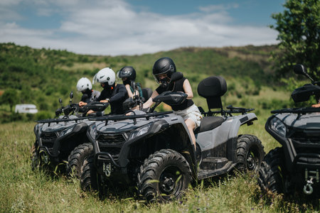 Group of friends riding quad bikes through a scenic countryside landscape
