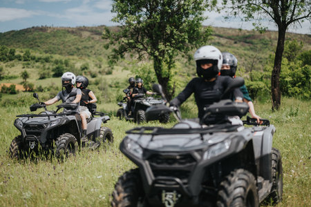 Group enjoying quad biking adventure through lush outdoor terrain on a sunny day