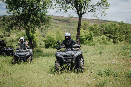 Group of friends riding quad bikes through a scenic grassy countryside