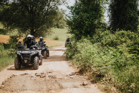 Group of friends riding quad bikes on a scenic dirt path in natureの写真素材
