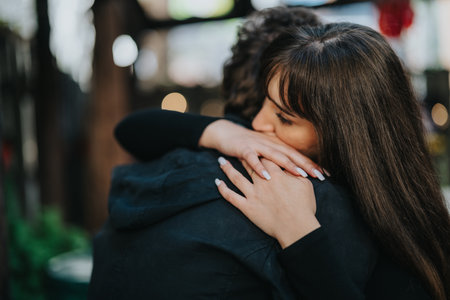 Woman warmly hugging a loved one in an emotional outdoor sceneの写真素材