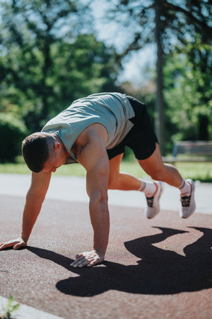 Man exercising outdoors performing plank exercises under a sunny sky in a park