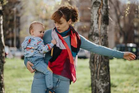 Mother holding her young child in an outdoor park setting