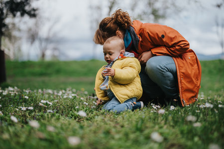 Mother and child spending time outdoors in a peaceful field with flowersの写真素材