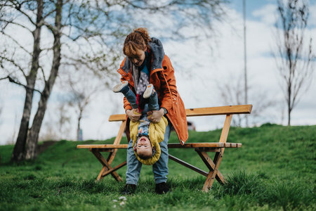 Mother playing joyfully with her child outdoors in a parkの写真素材